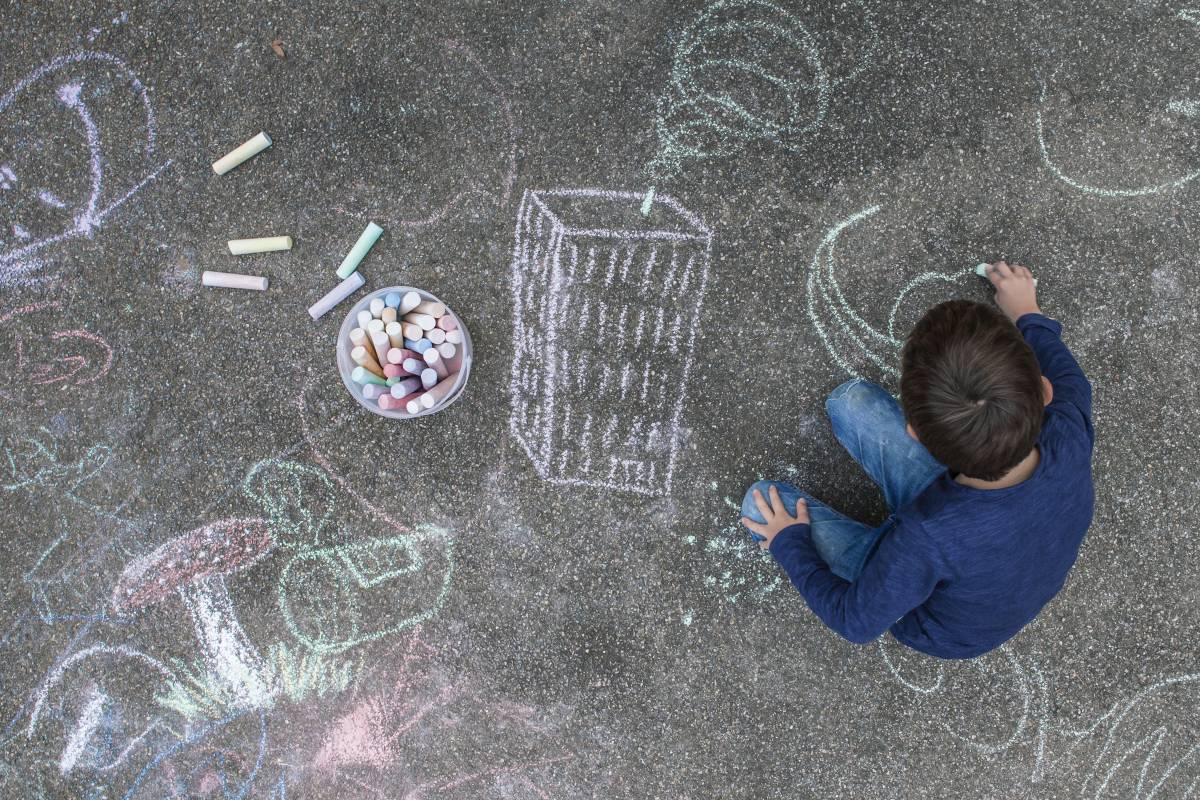 Мальчик рисует мелками